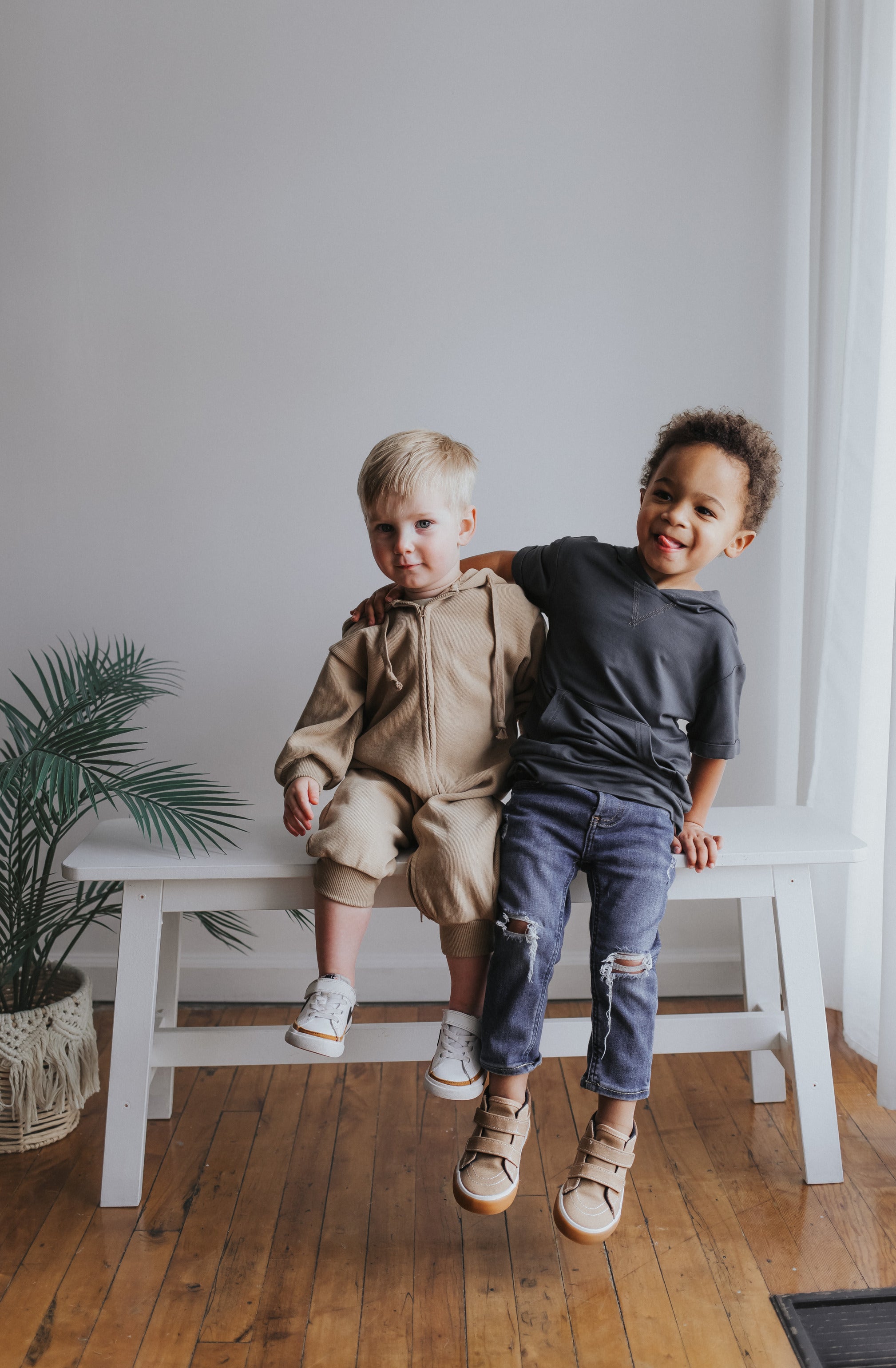 Two boys wearing modern jumpsuit, jeans, and graphic tee