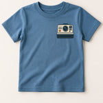 Blue t-shirt with a camera graphic on a beige background