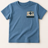 Blue t-shirt with a camera graphic on a beige background