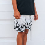 Person wearing black and white patterned shorts with a plain background