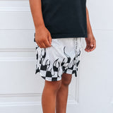 Person wearing black and white patterned shorts with a plain background
