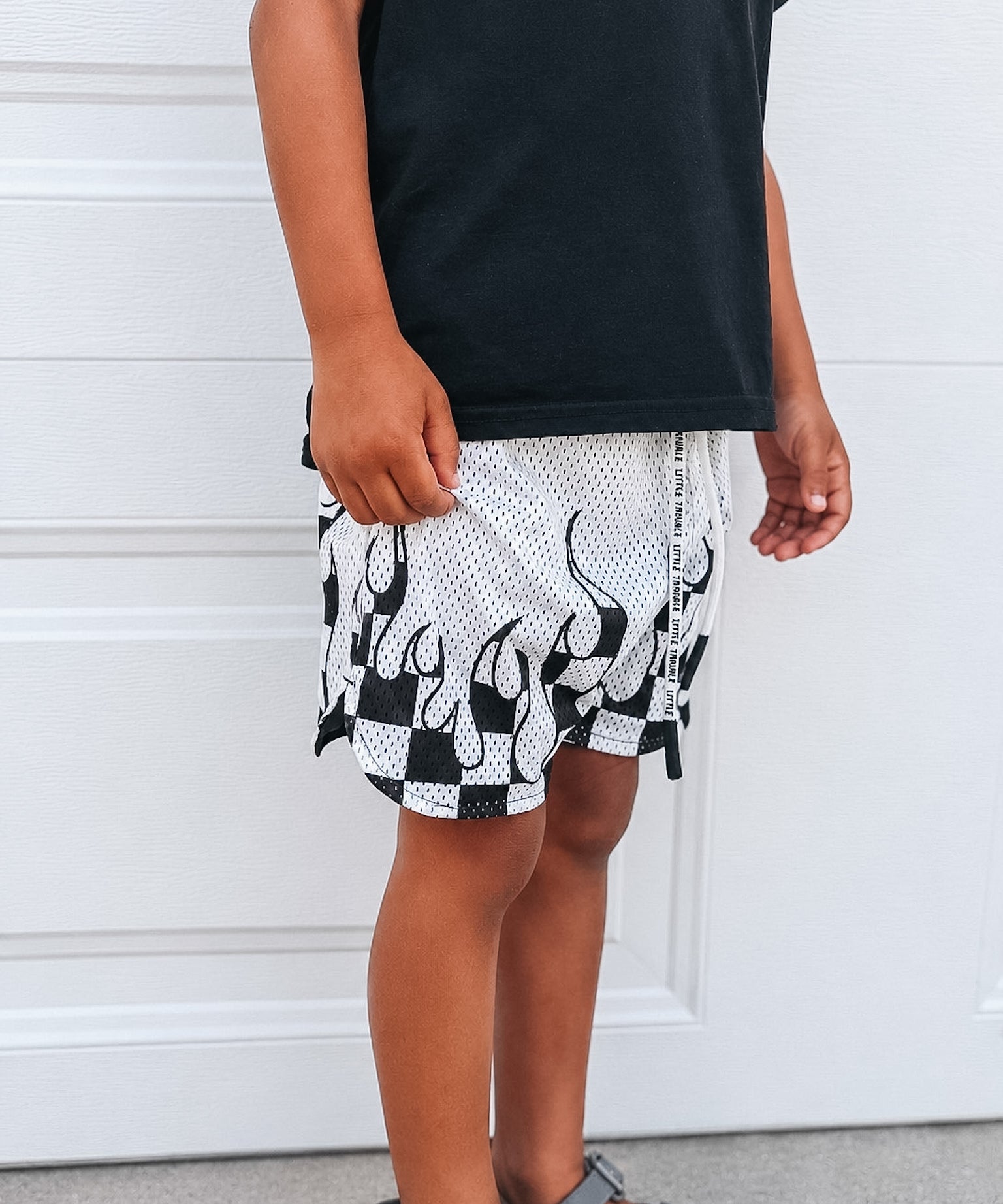 Person wearing black and white patterned shorts with a plain background