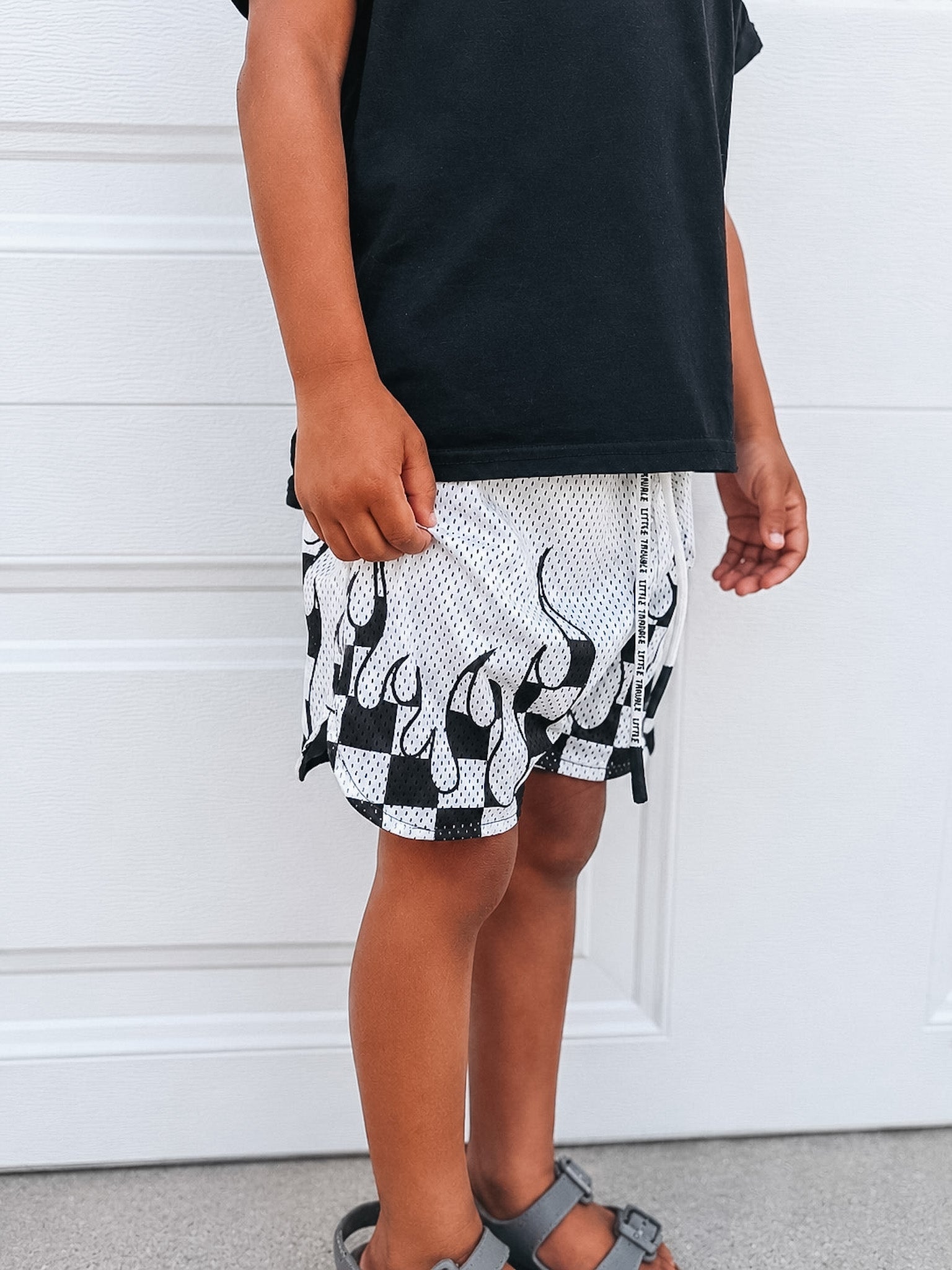 Person wearing black and white patterned shorts with a plain background