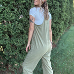 Women outside wearing an olive harem jumpsuit with sneakers.