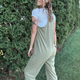 Women outside wearing an olive harem jumpsuit with sneakers.