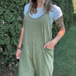 Women outside wearing an olive harem jumpsuit with sneakers.