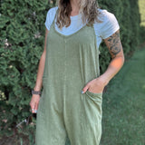 Women outside wearing an olive harem jumpsuit with sneakers.