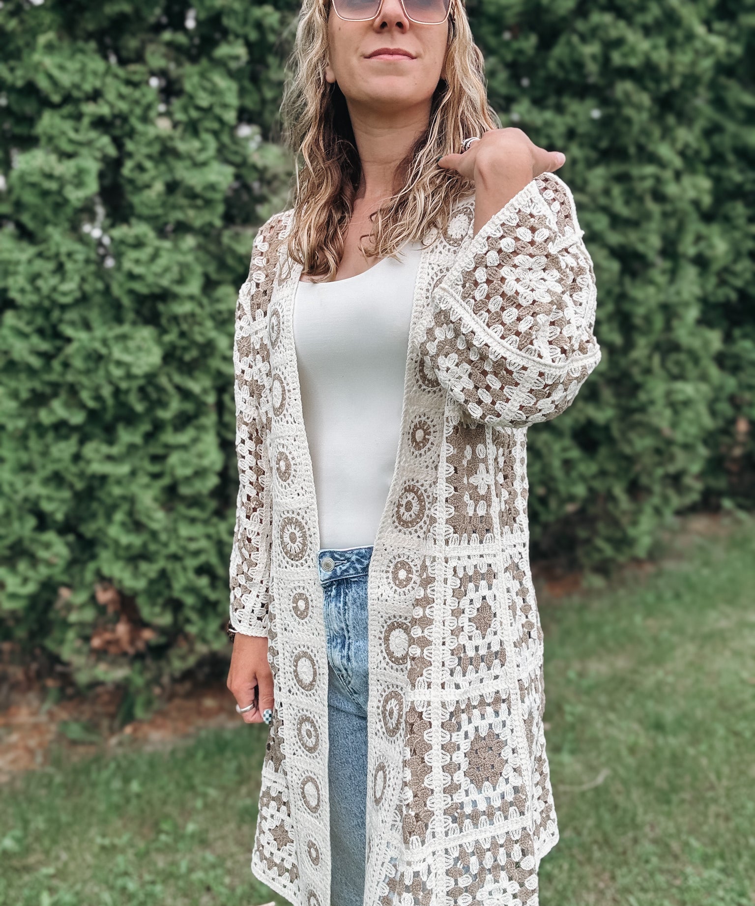 Woman wearing a patterned crochet cardigan outdoors