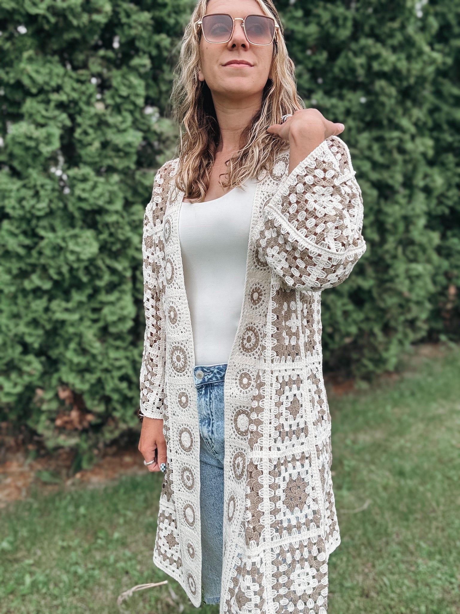 Woman wearing a patterned crochet cardigan outdoors