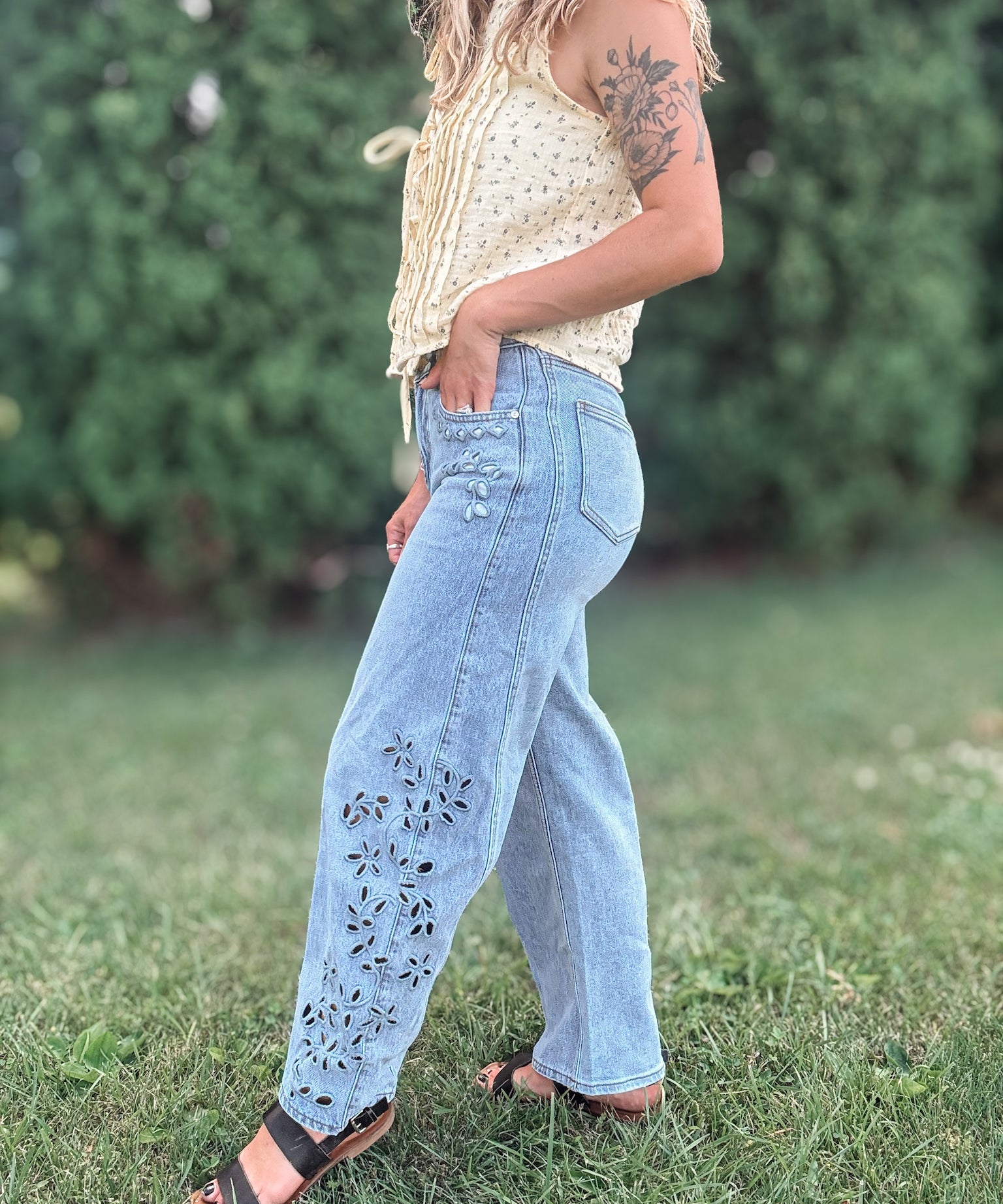 Side view of Women in Embroidered Floral Jeans Outside.