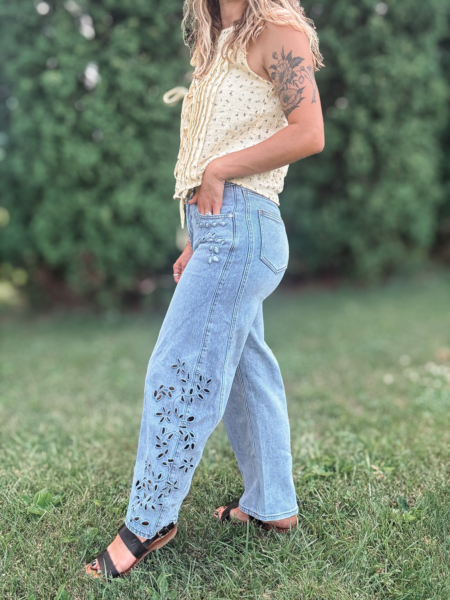 Side view of Women in Embroidered Floral Jeans Outside.