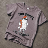 A short-sleeve crewneck t-shirt in a washed, heathered dark gray or charcoal color, laid flat on a textured concrete surface. The shirt features a graphic of a cartoon ghost wearing an orange cap and sunglasses while holding an orange skateboard, with the text 'TOO GHOUL FOR SCHOOL' printed in black arched above and below the illustration.