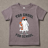 A kids' short-sleeve t-shirt in a washed, heathered mauve-purple color, featuring a cartoon graphic of a ghost dressed as a skateboarder with the text 'TOO GHOUL FOR SCHOOL'. The t-shirt is laid flat on a textured gray concrete surface.