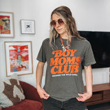 Woman wearing a 'Boy Moms Club' t-shirt in a living room setting