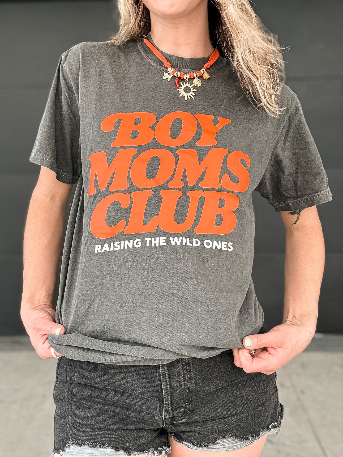 Person wearing a gray t-shirt with 'BOY MOMS CLUB' text in orange.