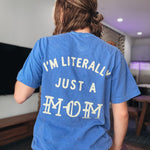 Person wearing a blue t-shirt with text on the back in a room.