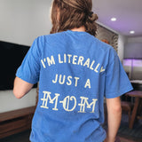 Person wearing a blue t-shirt with text on the back in a room.