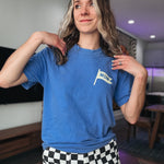 Person wearing a blue t-shirt with a 'mom' flag design in a room.