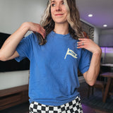 Person wearing a blue t-shirt with a 'mom' flag design in a room.