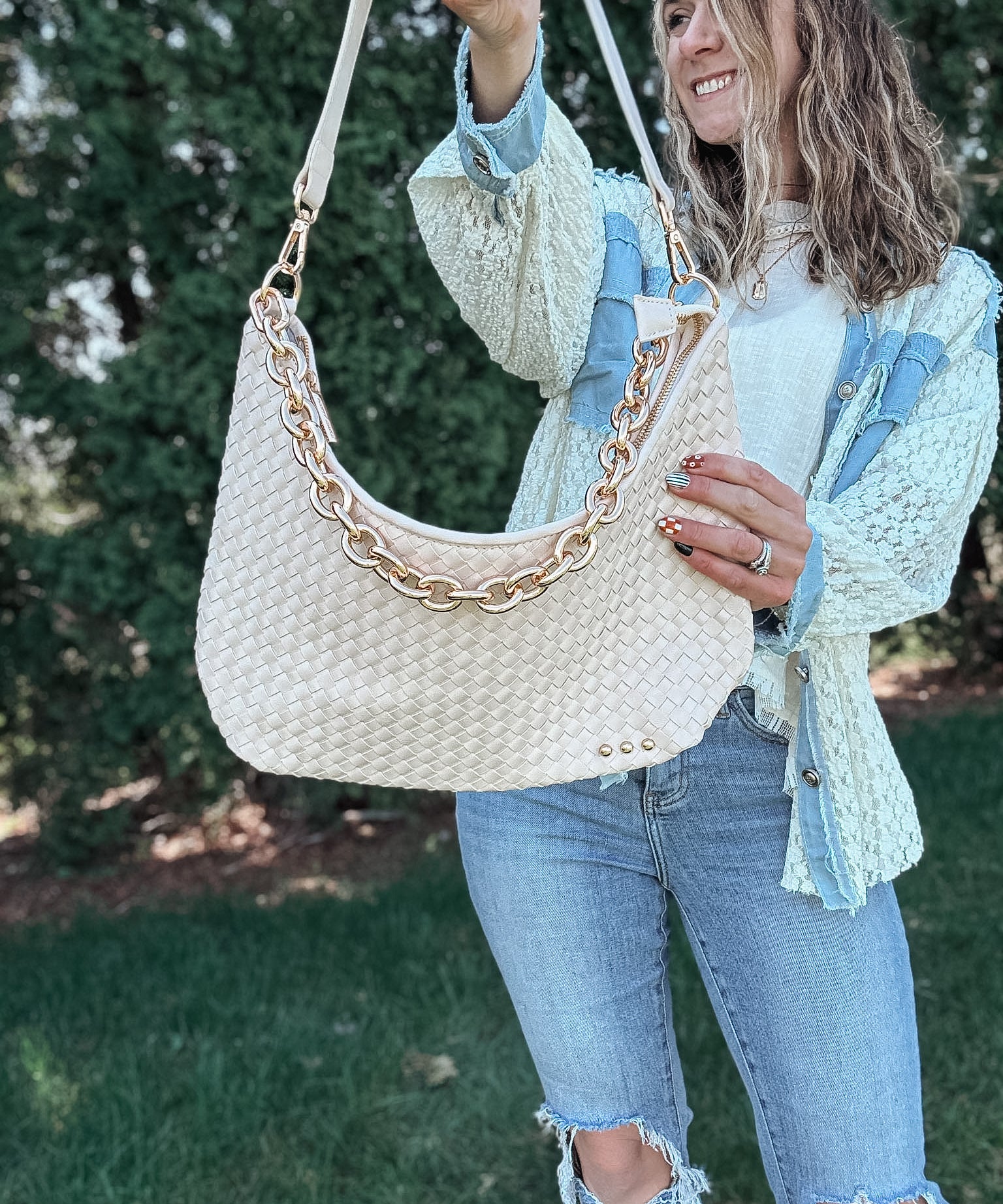 Woman wearing a white cream woven bag on her shoulder. 