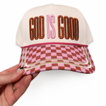 Cap with 'God is Good' text and checkered pattern held by a hand on a white background
