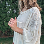 Person wearing a light-colored, patterned kimono-style garment outdoors.