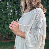 Person wearing a light-colored, patterned kimono-style garment outdoors.
