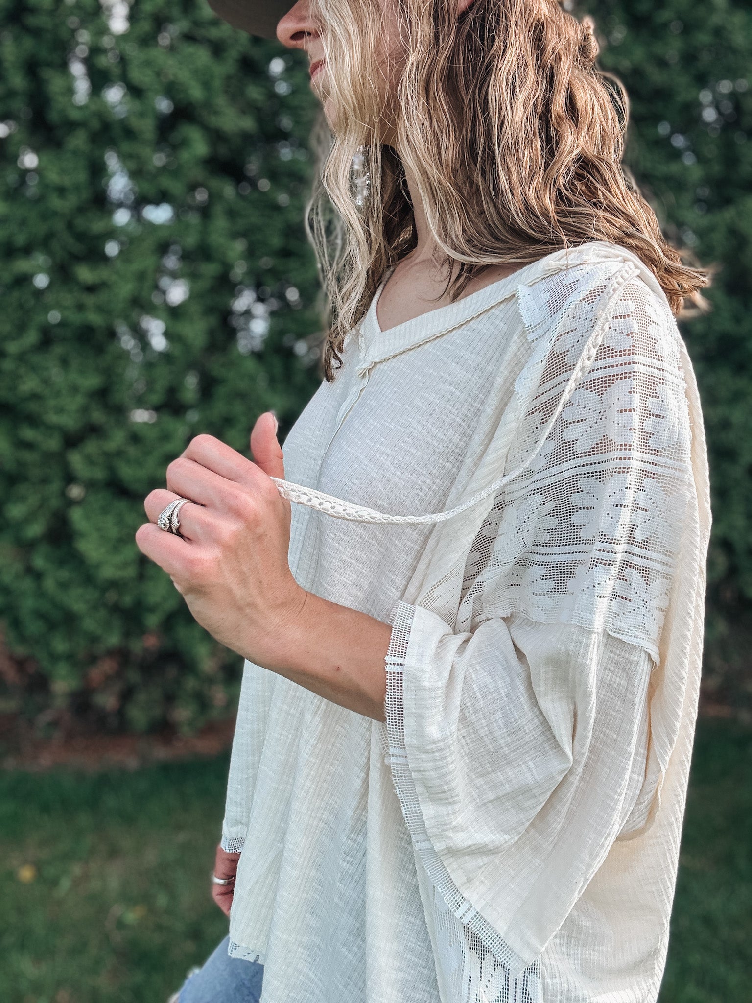 Person wearing a light-colored, patterned kimono-style garment outdoors.