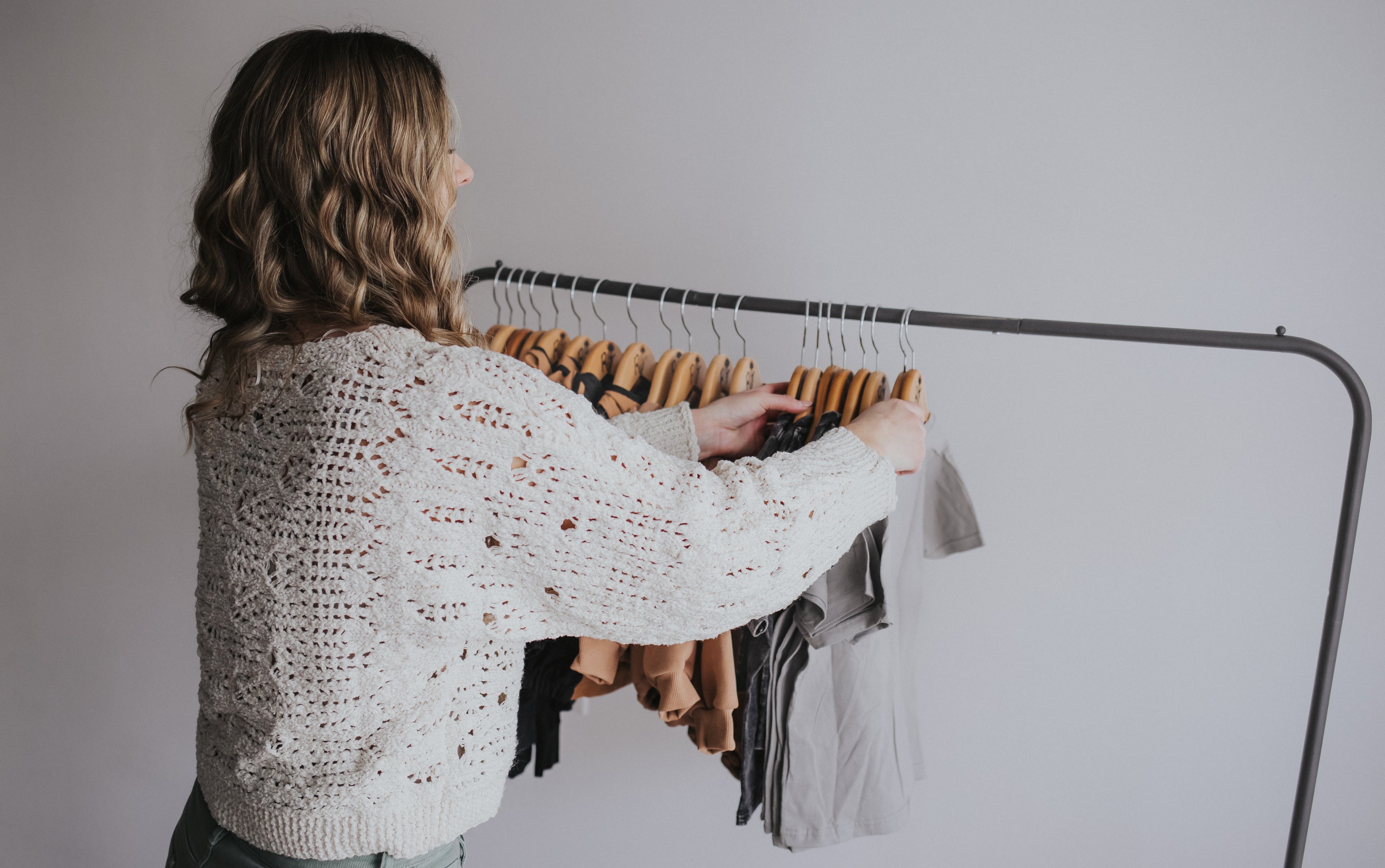 Founder standing at a rack of stylish and modern toddler boy clothing 