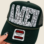 Hand holding Olive Green Amen Trucker Hat.